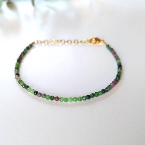 Peut inclure: Un bracelet délicat composé de petites perles de pierres précieuses vertes, roses et noires. Le bracelet a un fermoir en or.