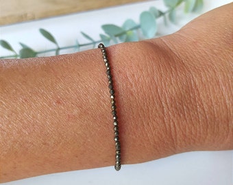 May include: A delicate bracelet made of small, faceted pyrite beads. The bracelet is a simple, elegant design and is perfect for everyday wear.