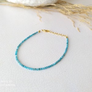 Può includere: Un delicato braccialetto di pietre blu con chiusura dorata. Il braccialetto è realizzato con piccole perle rotonde ed è perfetto per l'uso quotidiano.