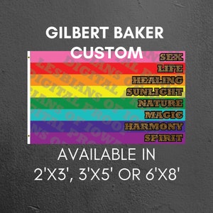 Puede incluir: Una bandera del orgullo arcoíris con las palabras "Gilbert Baker Custom" en la parte superior y las palabras "Sex, Life, Healing, Sunlight, Nature, Magic, Harmony, Spirit" en letras doradas con purpurina en cada franja. La bandera está disponible en tres tamaños: 2'x3', 3'x5' o 6'x8'.