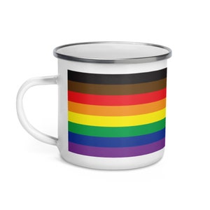 May include: White enamel mug with a rainbow flag design. The flag has black, red, orange, yellow, green, blue, and purple stripes.