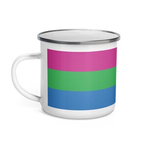 May include: A white enamel mug with a pink, green, and blue striped design. The mug has a silver rim and a white handle.
