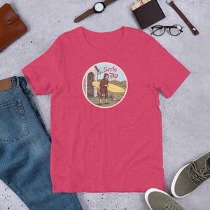 Serfs Up Shirt (V2) – Medieval Peasant with Surfboard – Illuminated Manuscript Tee – Funny History Pun – Unisex Vintage Graphic T-Shirt