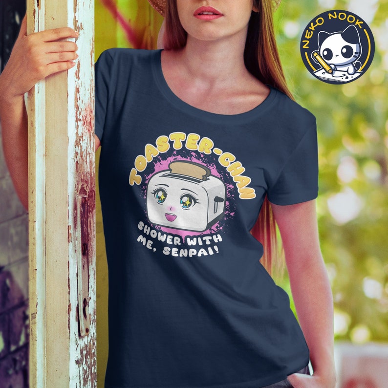 May include: A navy blue t-shirt with a pink and yellow graphic of a cartoon toaster with a face and the text "Toaster-Chan Shower With Me, Senpai!"