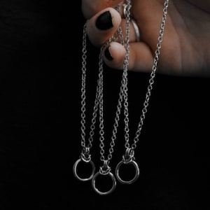 Op de afbeelding: Drie zilveren kettingen met kleine zilveren ring hangers.