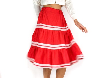 Falda ancha de color rojo brillante de los años 70. Ambiente flamenco. Detalles de malla blanca. Cintura elástica. Largo de rodilla.