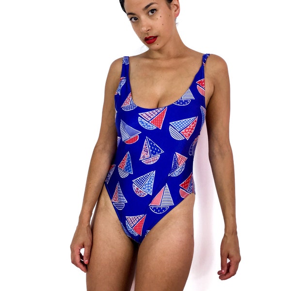 80s vintage one-piece bathing suit. Blue with little  red, white and blue sailboats. Open back. High at the legs.