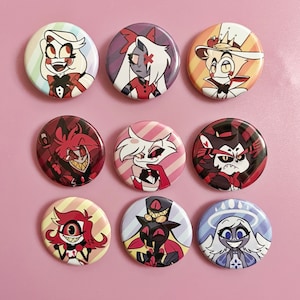 May include: Nine round pinback buttons featuring colorful cartoon character illustrations. The buttons showcase various characters with distinct facial expressions and attire, set against a light pink background. The designs include a variety of colors and styles.