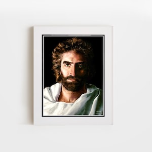 Puede incluir: Retrato enmarcado de un hombre con cabello castaño y barba, sobre un fondo negro. El hombre lleva una prenda blanca. La obra de arte se presenta en un marco blanco con un borde negro.