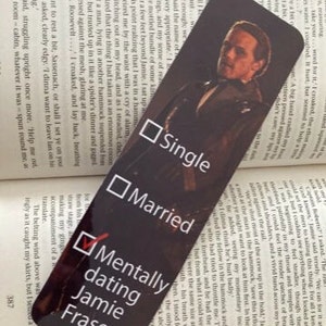 Op de afbeelding: Een zwarte bladwijzer met een foto van Jamie Fraser uit de serie Outlander. De bladwijzer heeft een vinkje naast "Mentally dating Jamie Fraser" en niet aangevinkte vakjes naast "Single" en "Married".
