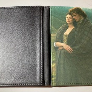May include: Black faux leather passport holder featuring a printed image of a couple in historical attire. The image is on the right side of the open holder. The left side is plain black.