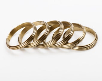May include: Set of six gold-toned metal napkin rings with a ridged design.