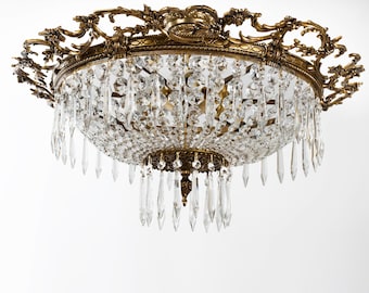 May include: A gold-toned crystal chandelier with a decorative, ornate frame and a large number of crystal drops.