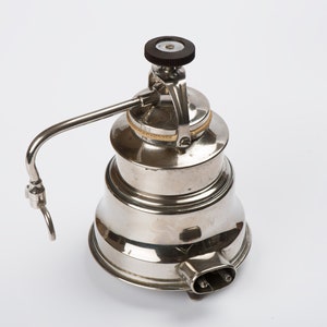 Peut inclure: Une cafetière à espresso électrique en argent avec un bouton noir sur le dessus et un cordon.