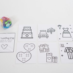 May include: A set of eight black and white printable cards with wedding-themed illustrations. The cards include a wedding cake, a car, a wedding dress, a pair of shoes, a heart, a gift box, a tuxedo, and a pair of shoes. The cards are designed to be colored in. The text on the card reads "Our Wedding Day Alison & Jason March 13, 2020".