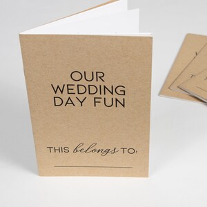 May include: A brown paper booklet with the text "OUR WEDDING DAY FUN" and "THIS belongs TO:" printed on the front cover.
