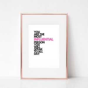 Puede incluir: Una impresión enmarcada con el texto "You are the most influential person you will speak to all day". La palabra "influential" está en rosa y el resto del texto está en negro.
