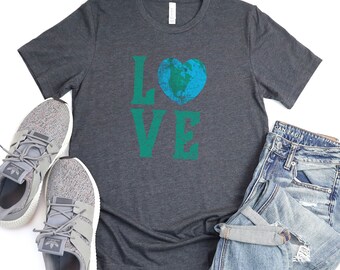 Puede incluir: Una camiseta gris oscuro con un gráfico verde y azul de la palabra "LOVE" con una tierra en forma de corazón en la "O".