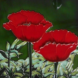 May include: A square ceramic tile with a floral design. Two large red poppy flowers with detailed petals are set against a dark green background. Green leaves and stems add to the botanical theme.