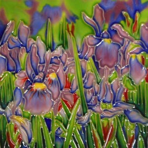 Puede incluir: Azulejo de cerámica con un diseño floral de iris. Los iris tienen pétalos morados, azules y rosas con centros amarillos, sobre un fondo verde y azul. La obra de arte tiene un acabado brillante.