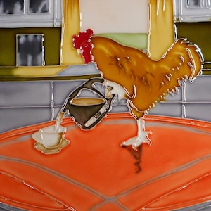 May include: A ceramic tile featuring a rooster pouring coffee into a cup. The rooster is brown and yellow with a red comb, set against a background of gray, orange, and yellow. The tile has a glossy finish.