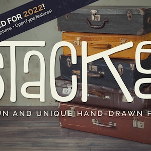 Puede incluir: Una fuente dibujada a mano de color blanco llamada "Stacked" con el texto "UPDATED FOR 2022! Over 50 new ligatures - OpenType features!" encima. La fuente se muestra sobre una pila de cuatro maletas vintage.
