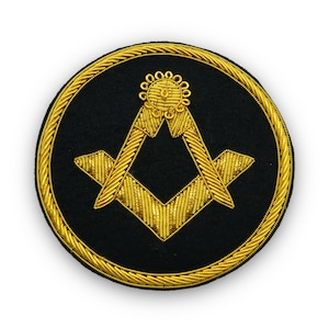 May include: A gold embroidered Masonic symbol on a black circular patch. The symbol is a square and compass with a small circle at the top.