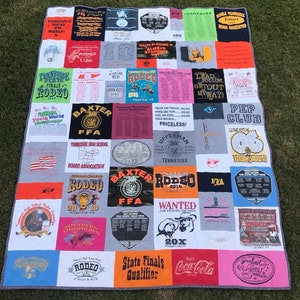 May include: A patchwork quilt made from t-shirts with a rodeo theme. The quilt is made up of squares of different colours and patterns, with many of the squares featuring the word "Rodeo" or images of rodeo events. The quilt is a great way to show your love of rodeo and to remember your favourite rodeo memories.