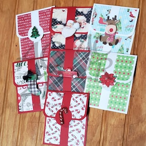 May include: A collection of handmade Christmas gift card holders. Each card holder features festive designs, including Santa Claus, reindeer, candy canes, and plaid patterns. Embellishments include glittery accents and die-cut shapes.