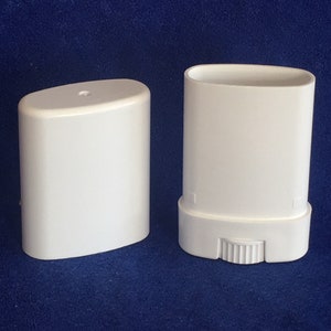 May include: Two white plastic deodorant containers, one with a twist-up mechanism. The containers are oval-shaped and have a smooth, matte finish.