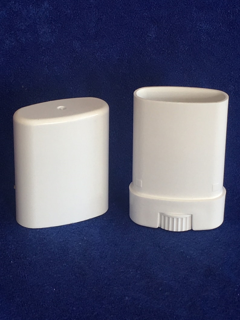 May include: Two white plastic deodorant containers, one with a twist-up mechanism. The containers are oval-shaped and have a smooth, matte finish.