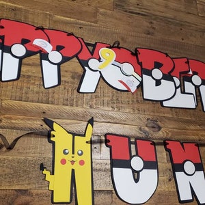 May include: A red, white, and black banner with the words "Happy Birthday" and "Hunt" in large letters. The letters are decorated with images of Pikachu and Pokeballs.