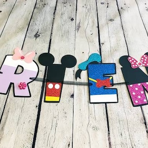 May include: A colorful Disney-themed banner with the name "DARITENA" spelled out in large letters. Each letter is decorated with a different Disney character, including Mickey Mouse, Minnie Mouse, Donald Duck, Goofy, and Pluto.