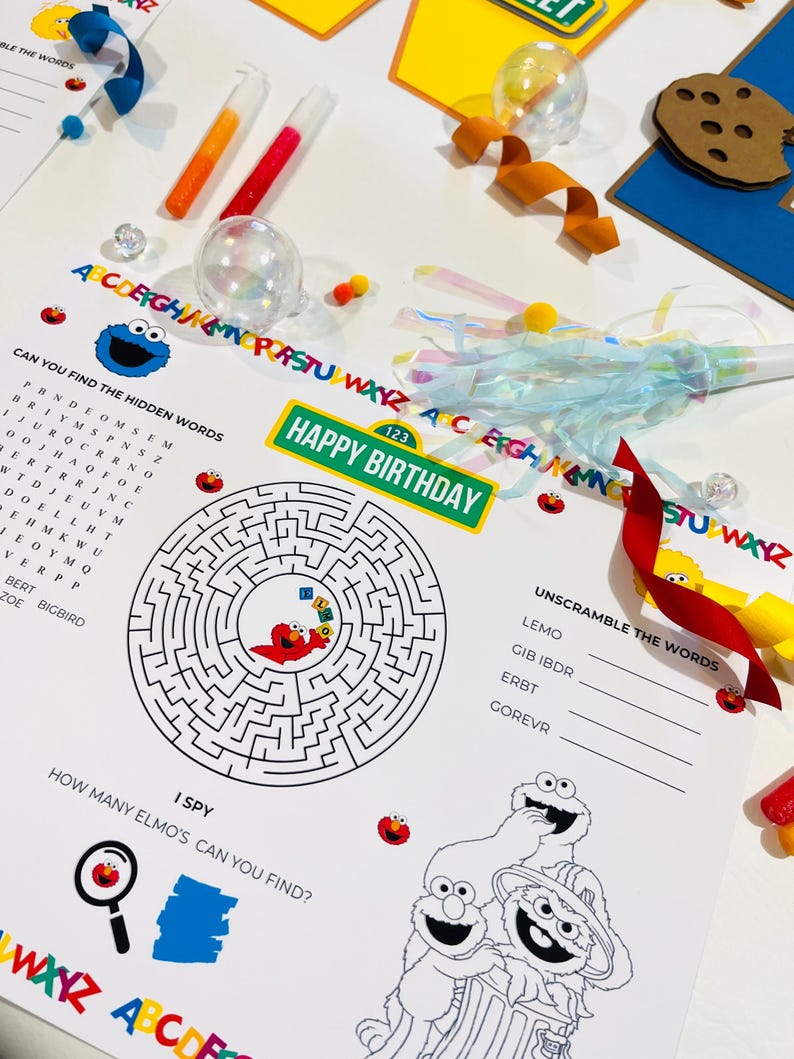 May include: A black and white printable activity sheet featuring Sesame Street characters Elmo, Cookie Monster, and Big Bird. The sheet includes a word search, a maze, a word scramble, and an I Spy game. The text on the sheet reads "Can you find the hidden words", "Happy Birthday", "Unscramble the words", "I Spy", and "How many Elmo's can you find?"