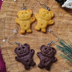 Peut inclure: Deux paires de boucles d'oreilles en forme d'ours. Une paire est brune et l'autre est jaune.