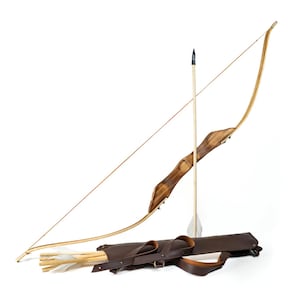 May include: A traditional archery set, featuring a wooden bow with a brown grip, a quiver, and several arrows. The bow is curved and strung, with one arrow nocked. The quiver is brown leather, and the arrows have white fletching. The set is on a white background.