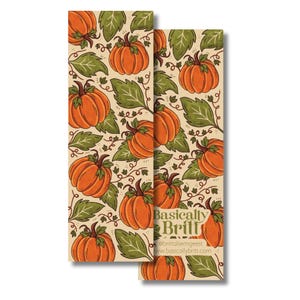 May include: A rectangular bookmark featuring a repeating pattern of orange pumpkins and green leaves on a light beige background. The text "Basically Britt" is printed in a dark green serif font near the bottom, along with social media handles.