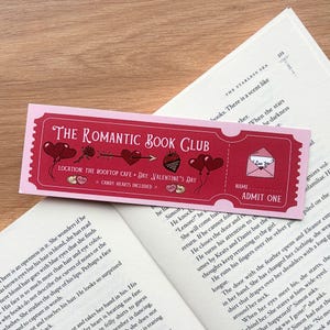 Könnte beinhalten: Lesezeichen in Rosa und Rot für "The Romantic Book Club" mit Herz- und Erdbeerillustrationen. Das Lesezeichen enthält den Text "Admit One" und ist zum Valentinstag gestaltet.