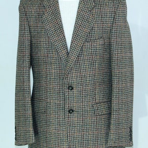 Puede incluir: Una chaqueta de tweed marrón, negro y rojo con cierre de dos botones.