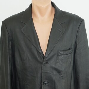 May include: A black leather blazer with a three-button closure and a single pocket on the left side.