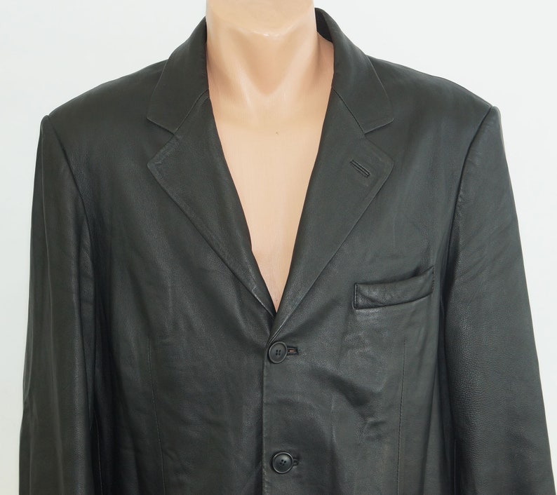 May include: A black leather blazer with a three-button closure and a single pocket on the left side.