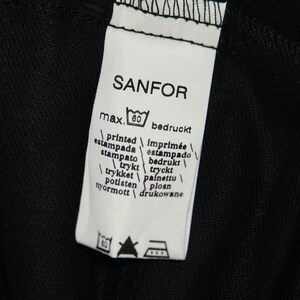 May include: White label with black text that reads "SANFOR" and includes a washing instruction icon. The label also includes the text "max. 60" and a list of words in multiple languages that translate to "printed".