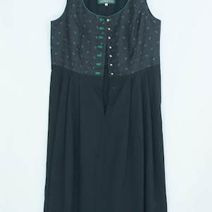 May include: A sleeveless black dirndl dress featuring a bodice with a small red cherry print and green trim. The bodice includes a row of silver-toned buttons and a green label with the text WENGER AUSTRIAN STYLE. The skirt is solid black.