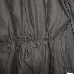 May include: Black jumpsuit with a drawstring waist.