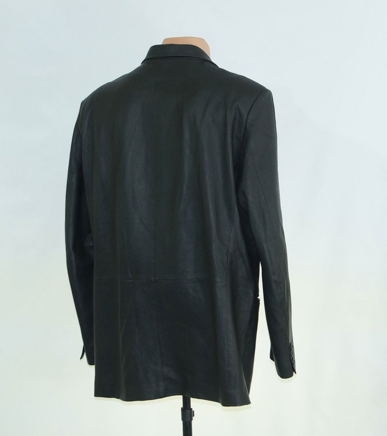 May include: A black leather blazer with a classic design. The blazer has a single-breasted closure, a notched lapel, and two front pockets.