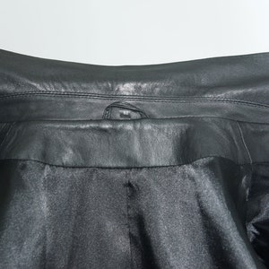 May include: Black leather jacket with a snap closure at the collar.