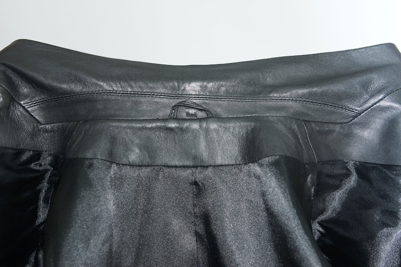 May include: Black leather jacket with a snap closure at the collar.