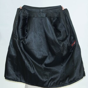 May include: Black leather jacket with a satin lining. The jacket has a zipper closure and a pocket on the inside.