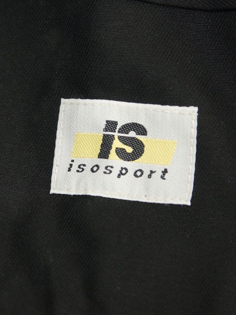 May include: A white label with black text that reads "is" in a large font and "isport" in a smaller font. The "is" is on a yellow background.