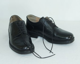 May include: A pair of black leather lace-up shoes with a polished finish. The shoes have a closed toe and a low heel.